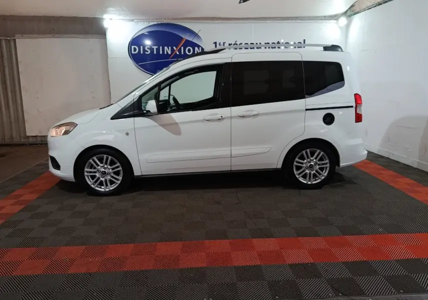 Vue de profil côté gauche d'un Ford Grand Tourneo Connect blanc 2020 avec vitres arrière teintées et jantes alliage.