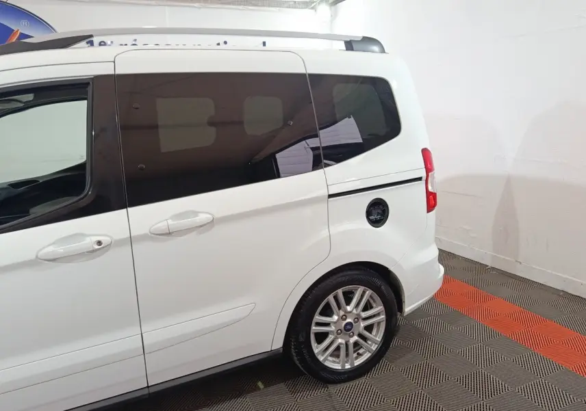 Vue latérale arrière droite d’un Ford Grand Tourneo Connect blanc avec vitres teintées et jantes alliage.