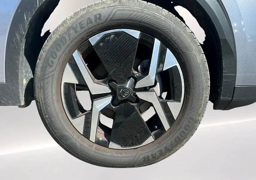 Gros plan sur la roue avant droite du Peugeot 2008 gris Artense avec jante alu bicolore et pneu Goodyear.