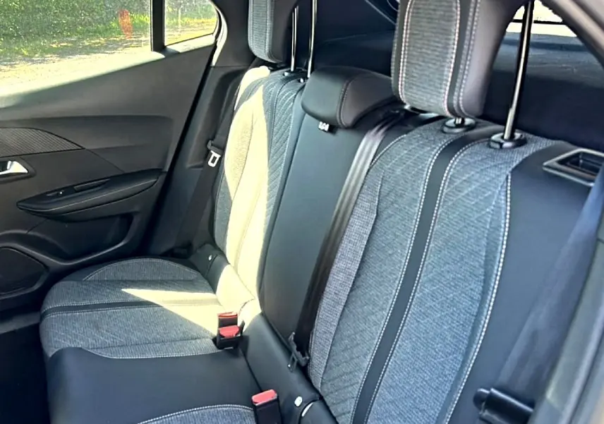 Vue intérieure de la banquette arrière du Peugeot 2008 2025 avec tissu gris et détails en cuir noir.