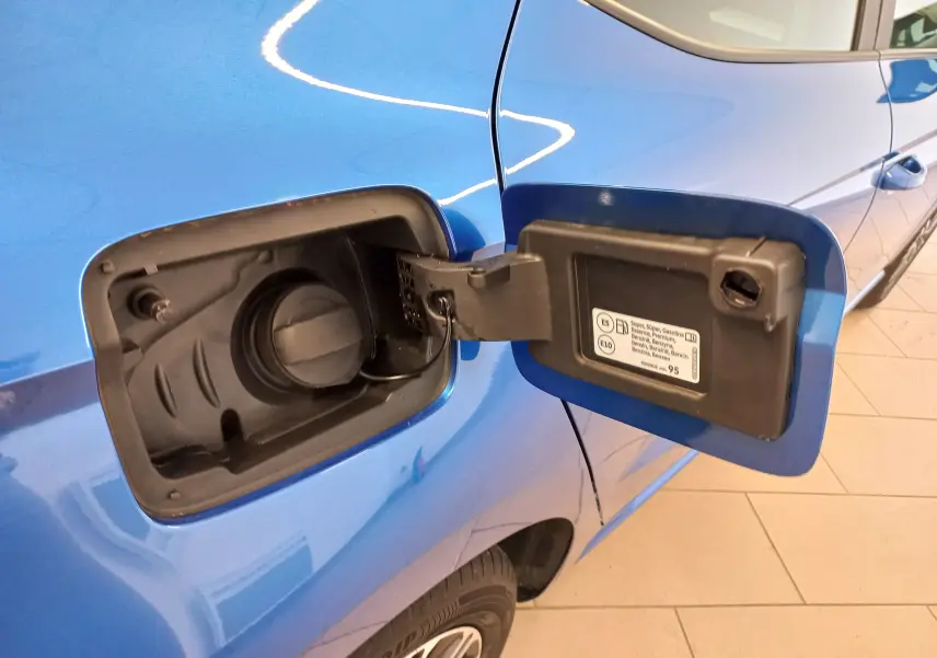 Vue rapprochée du volet de remplissage carburant ouvert côté gauche d'une SEAT Ibiza bleu saphir 2025.