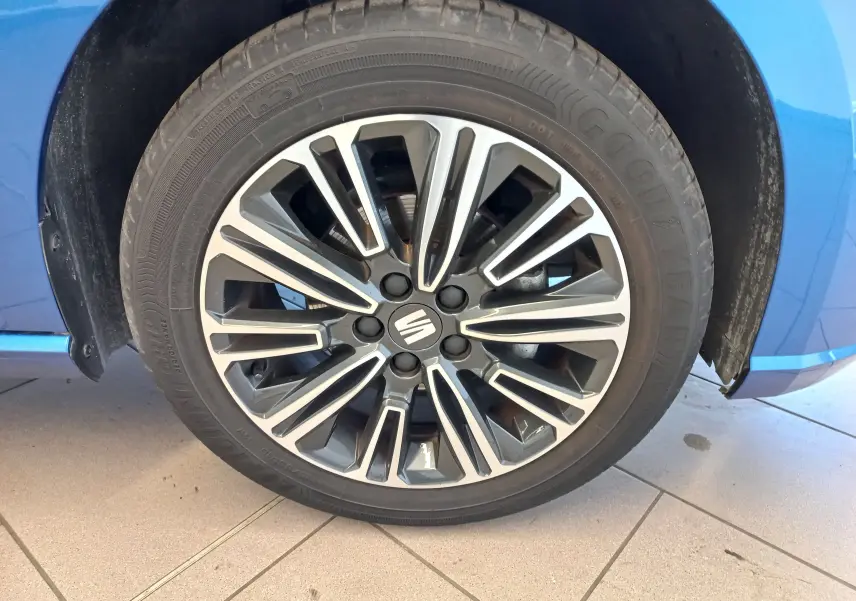 Gros plan sur la roue avant droite d'une SEAT IBIZA bleu saphir 2025 avec jante alliage à design moderne.
