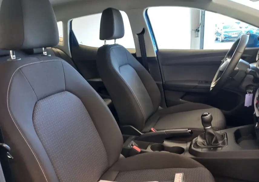 Vue intérieure côté droit du SEAT IBIZA 2025 bleu saphir, montrant les sièges avant noirs et la boîte manuelle.