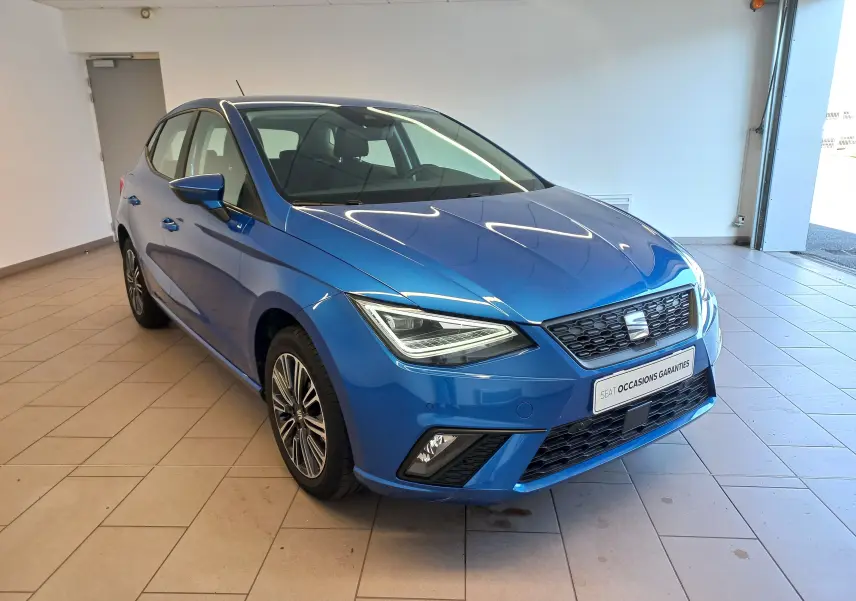 SEAT Ibiza 1.0 TSI 95 Copa bleu saphir vue 3/4 avant droit en intérieur avec jantes alliage distinctives.