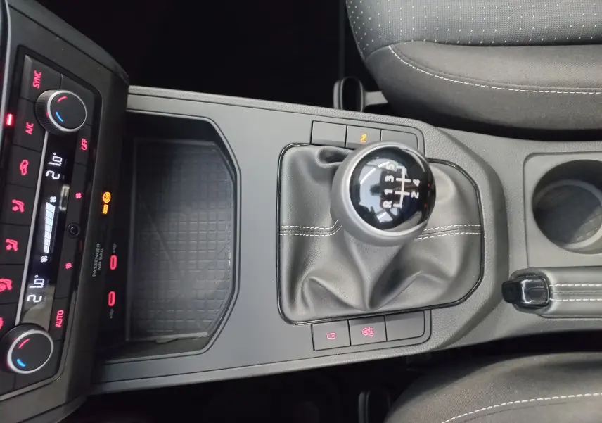 Vue plongeante sur la console centrale de la SEAT IBIZA 2025, levier de vitesse manuel et commandes climatisation visibles.