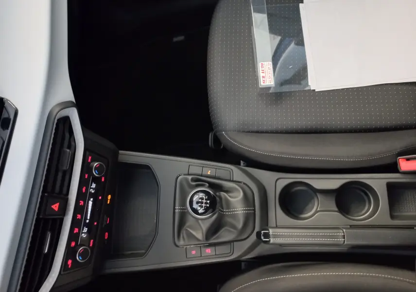 Vue intérieure centrée sur la console centrale de la SEAT Ibiza 2025 bleu saphir, avec levier de vitesse manuel et sièges gris.