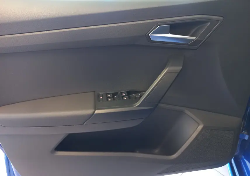 Vue rapprochée de la porte avant gauche bleu saphir de la SEAT Ibiza 2025 avec commandes de vitres et poignée argentée.