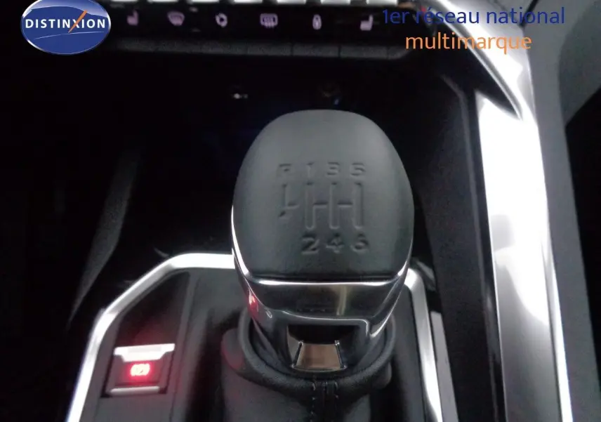 Gros plan sur le levier de vitesse manuel noir du Peugeot 3008 2023, entouré de finitions chromées et commandes éclairées.