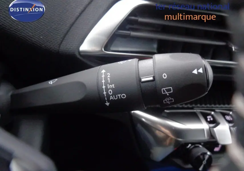 Gros plan sur la commande d’essuie-glace à gauche du volant dans l’habitacle noir du Peugeot 3008 noir perle metal 2023.