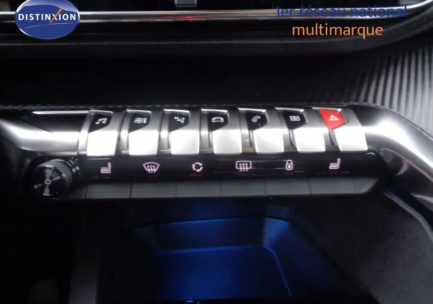 Gros plan sur la rangée de boutons argentés du tableau de bord du Peugeot 3008 noir perle, avec éclairage bleu dessous.