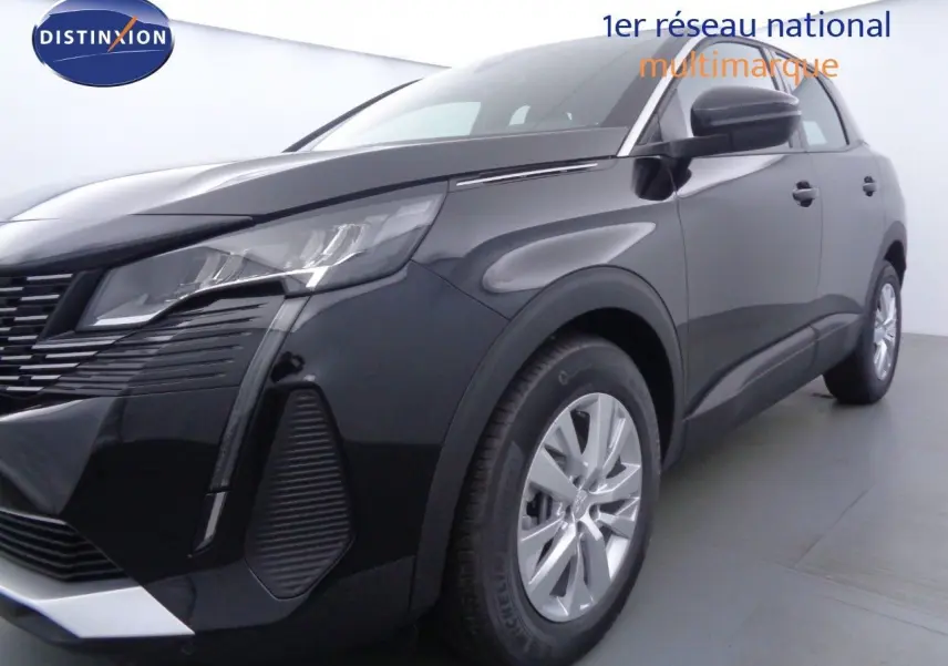 Gros plan sur la roue avant gauche d'un Peugeot 3008 noir perle métal avec jante alu et partie avant visible.