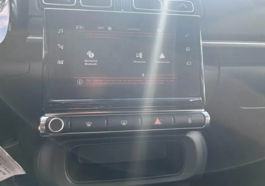 Écran tactile central avec commandes climatisation et alertes dans l'habitacle d'une Citroën C3 gris 2022.