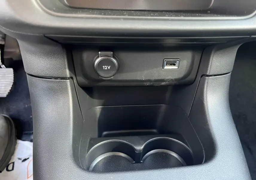 Gros plan sur la console centrale noire de la Citroën C3 2022 avec prise 12V et port USB visible.