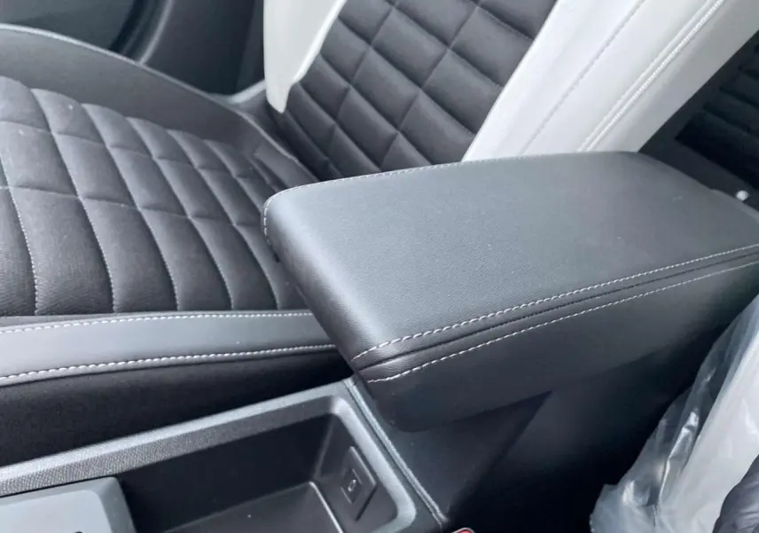 Accoudoir central noir et siège avant en tissu noir et gris clair de la Citroën C3 Aircross 2025 hybride.