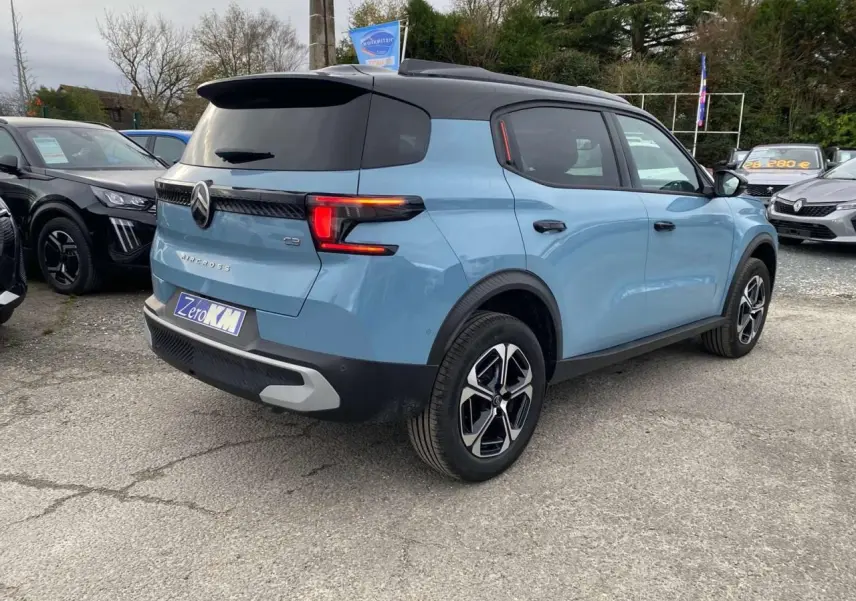 Vue 3/4 arrière droite d'une Citroën C3 Aircross bleu Monte Carlo avec toit noir et feux arrière LED distinctifs.