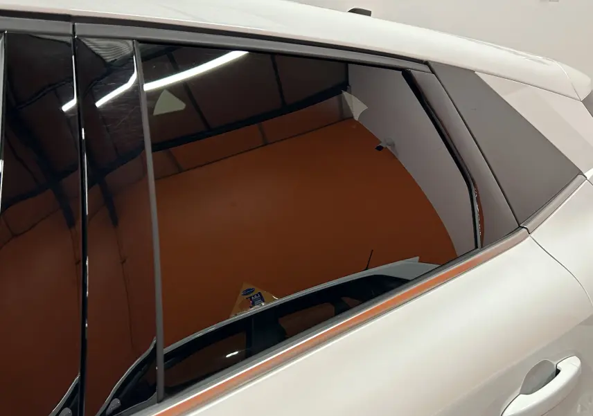 Vue latérale côté droit du Renault Symbioz blanc nacré, mettant en valeur la vitre teintée et la poignée de porte.