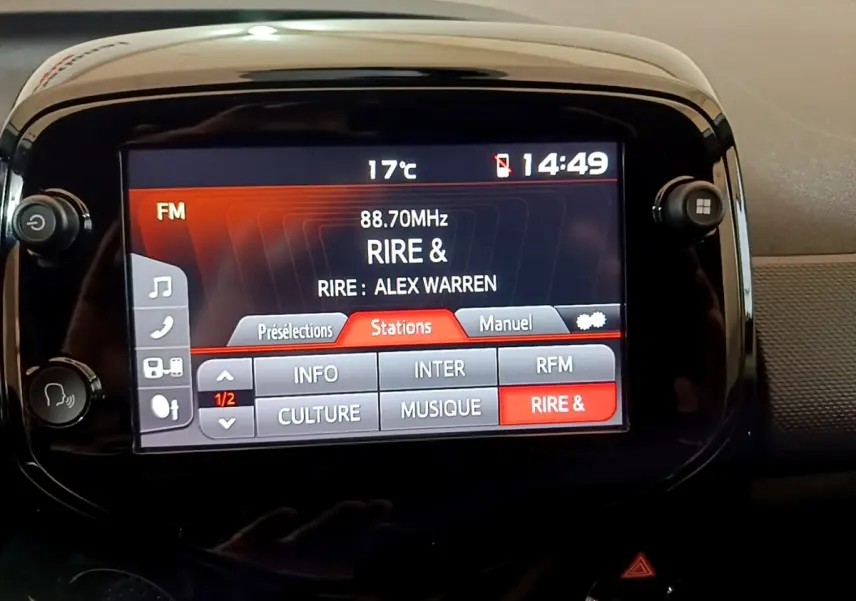 Écran tactile central de la Citroën C1 gris clair, affichant la radio FM avec station "RIRE &" en mode 14h49.