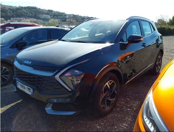 KIA SPORTAGE noir en 3/4 avant droit, mettant en valeur sa calandre distinctive et ses phares LED angulaires.