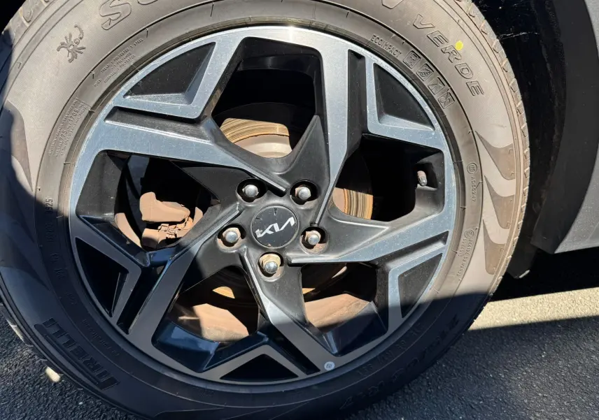 Gros plan sur la jante noire et grise du Kia Sportage 2022, mettant en valeur le logo central et le pneu Pirelli.
