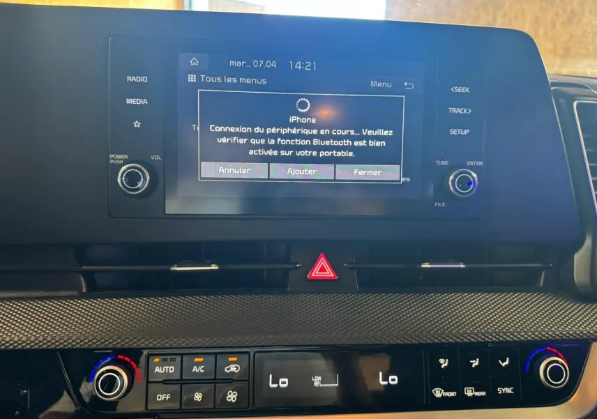 Tableau de bord intérieur du Kia Sportage 2022 avec écran tactile affichant connexion Bluetooth et commandes climatisation.