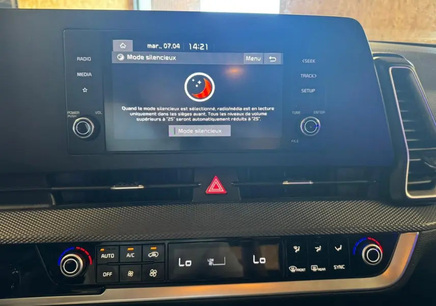 Vue rapprochée du tableau de bord noir du Kia Sportage 2022, avec écran tactile affichant le mode silencieux et commandes climatisation.