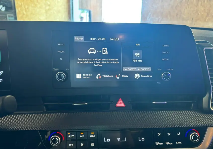 Vue rapprochée de l’écran tactile et de la console de climatisation du Kia Sportage noir 2022, intérieur moderne et fonctionnel.