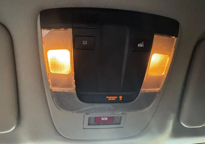 Plafonnier intérieur allumé avec boutons de commande et affichage SOS dans un Kia Sportage noir, vue de dessous.