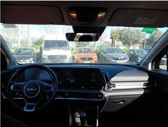 Vue 3/4 arrière droite d’un KIA Sportage noir 2022 avec feux arrière allumés et détails chromés sur le pare-chocs.