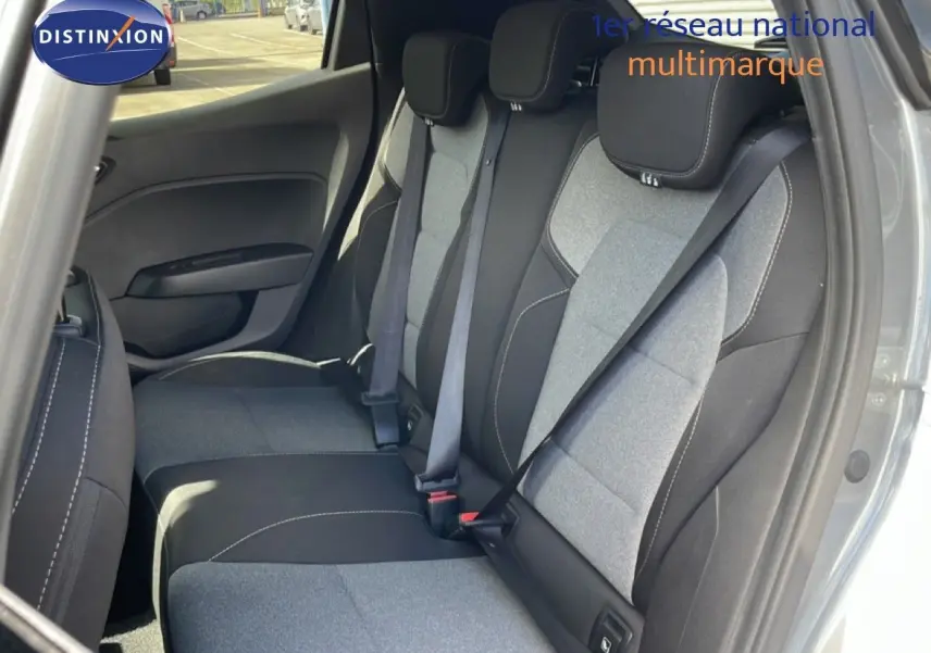 Vue intérieure arrière droite de la Renault Clio 2025, montrant les sièges tissu gris clair et noir avec ceinture de sécurité.
