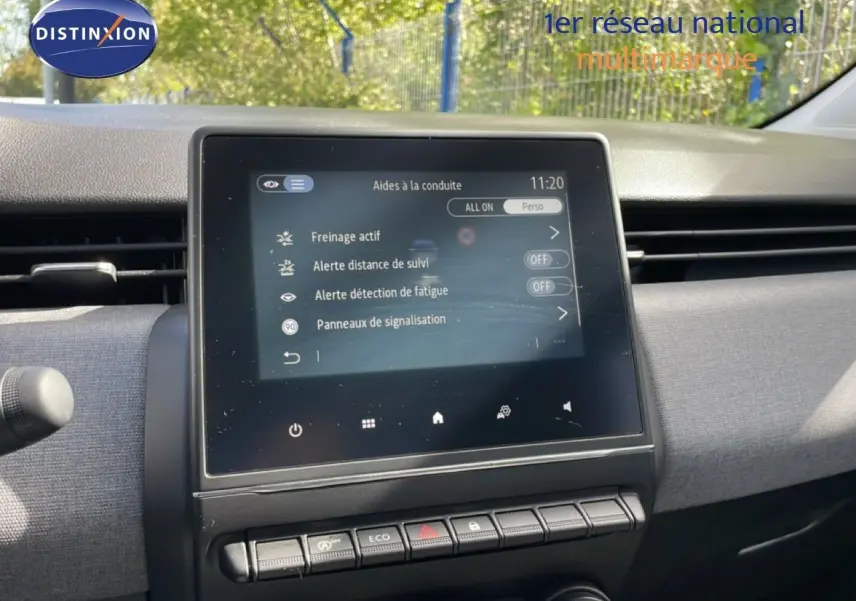 Vue rapprochée de l’écran tactile central du tableau de bord de la Renault Clio gris schiste métal, affichant les aides à la conduite.