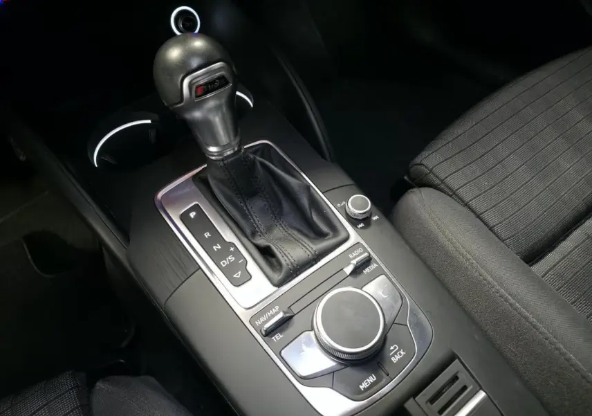 Gros plan sur la console centrale noire de l'Audi A3 Sportback avec levier de vitesse S tronic et commandes multimédia.