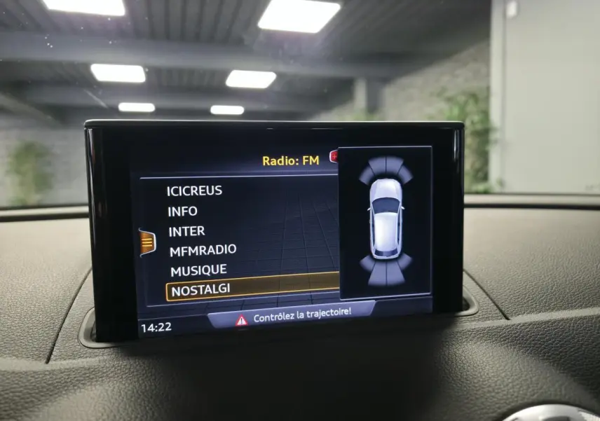 Écran central de l’Audi A3 Sportback 2019 affichant la sélection radio FM avec vue du véhicule en mode stationnement.