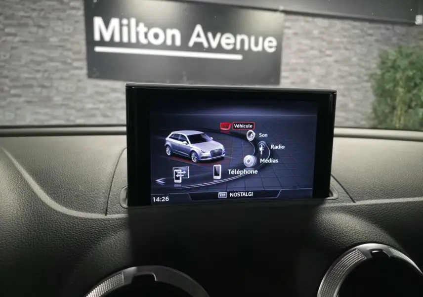 Écran central de l'Audi A3 Sportback affichant le menu multimédia, intérieur noir avec tableau de bord texturé.