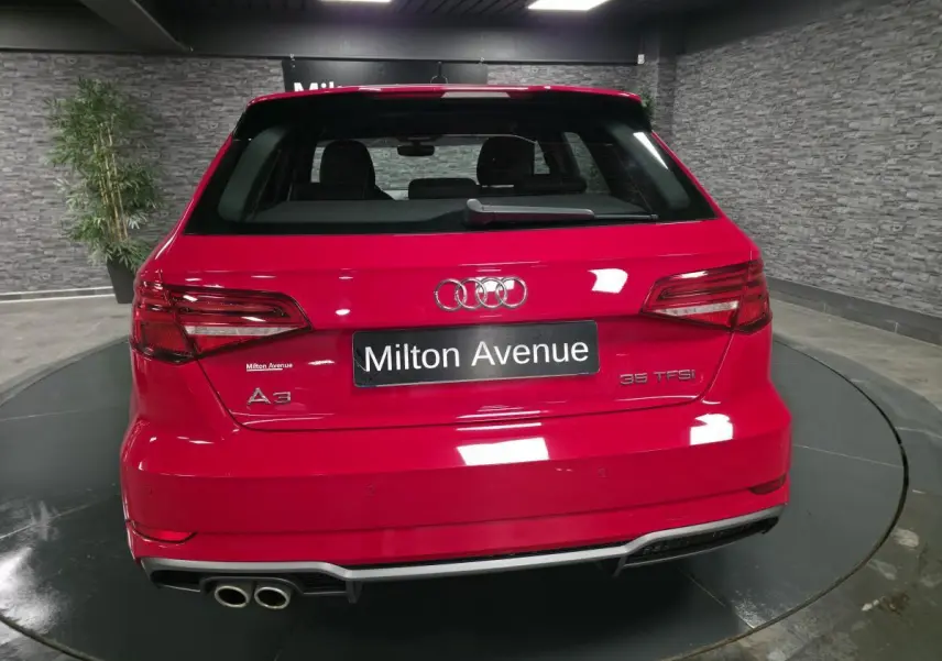 Vue arrière d'une Audi A3 Sportback rouge avec double sortie d'échappement et becquet de pavillon S line.