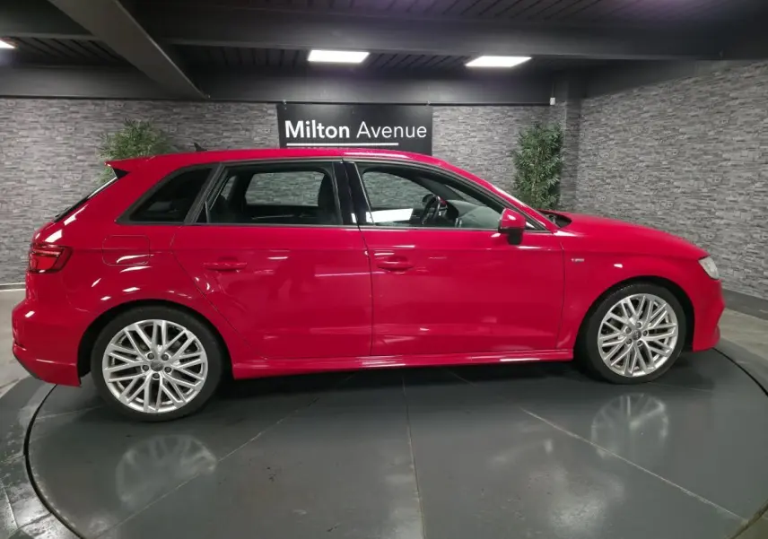 Audi A3 Sportback rouge vue de profil côté gauche, avec jantes Audi Sport 10 branches et becquet S line.