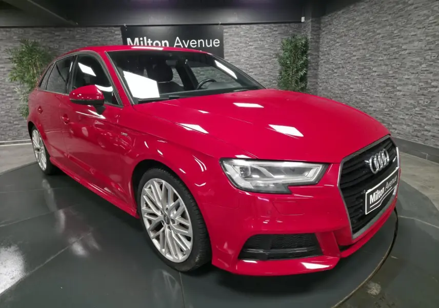 Audi A3 Sportback rouge vue 3/4 avant droit avec jantes Audi Sport 10 branches et calandre noir brillant.