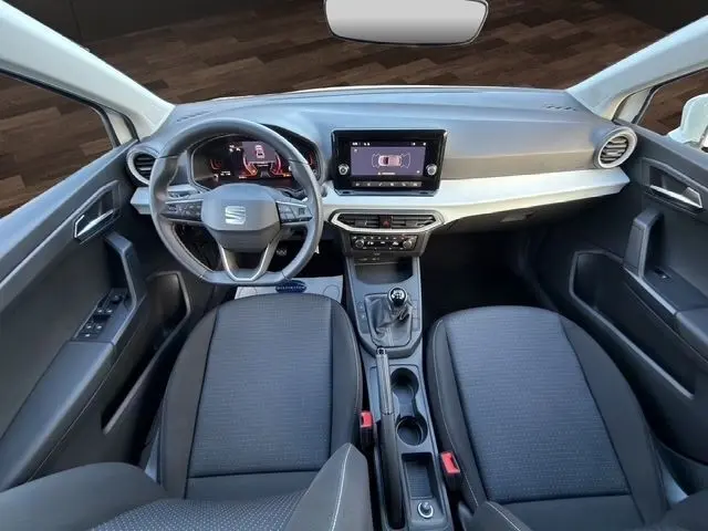 Vue intérieure avant de la SEAT Ibiza 1.0 MPI 80 Style 2023, volant cuir multifonctions et écran tactile central.