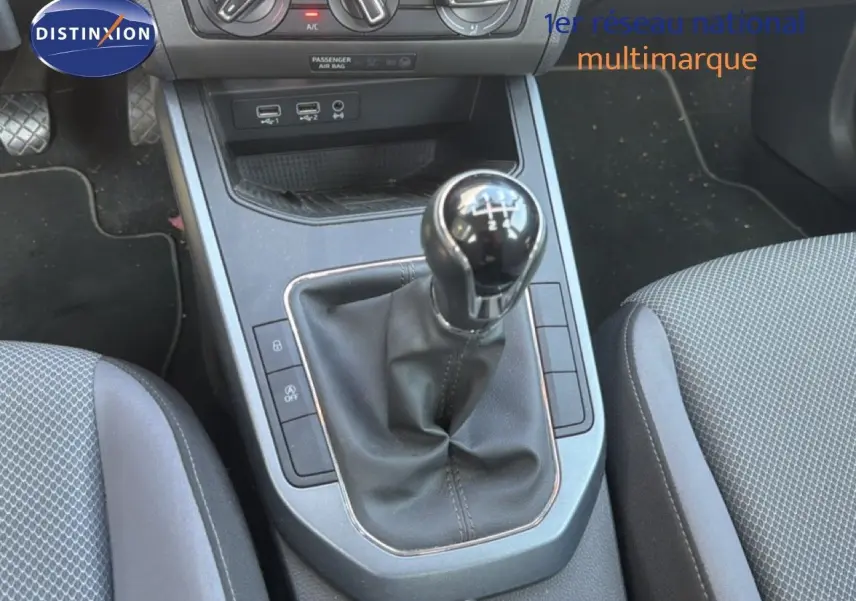 Vue rapprochée de la console centrale avec levier de vitesses manuel du SEAT Arona gris urbain, intérieur tissu gris.
