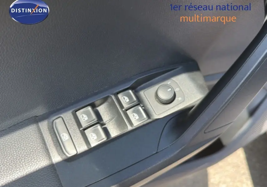 Gros plan sur les commandes des vitres et rétroviseurs côté conducteur d’un SEAT Arona gris urbain avec toit noir.