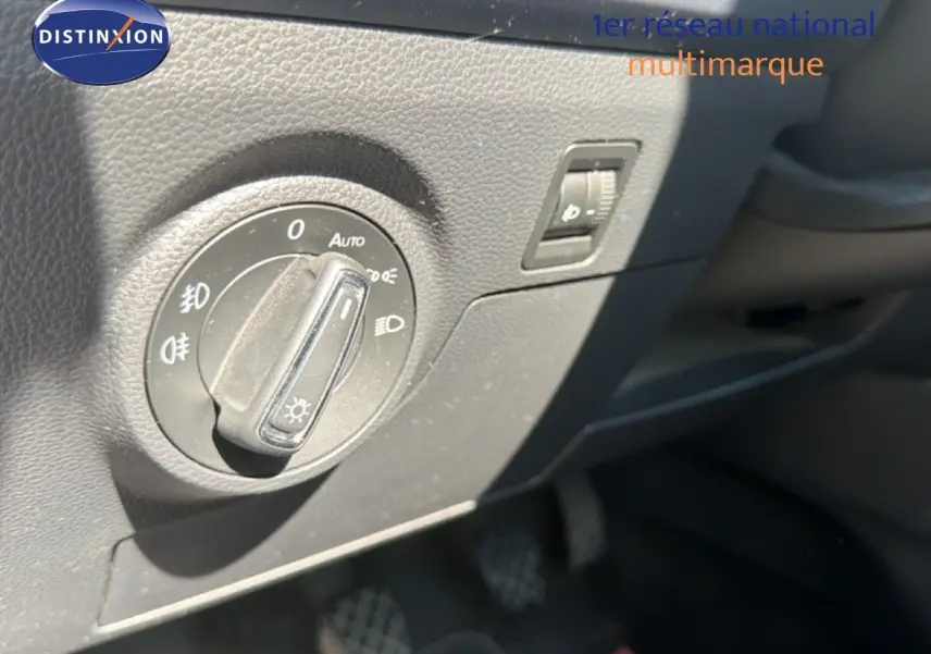 Gros plan sur le bouton de commande des phares dans l’habitacle d’un SEAT Arona gris urbain toit noir.