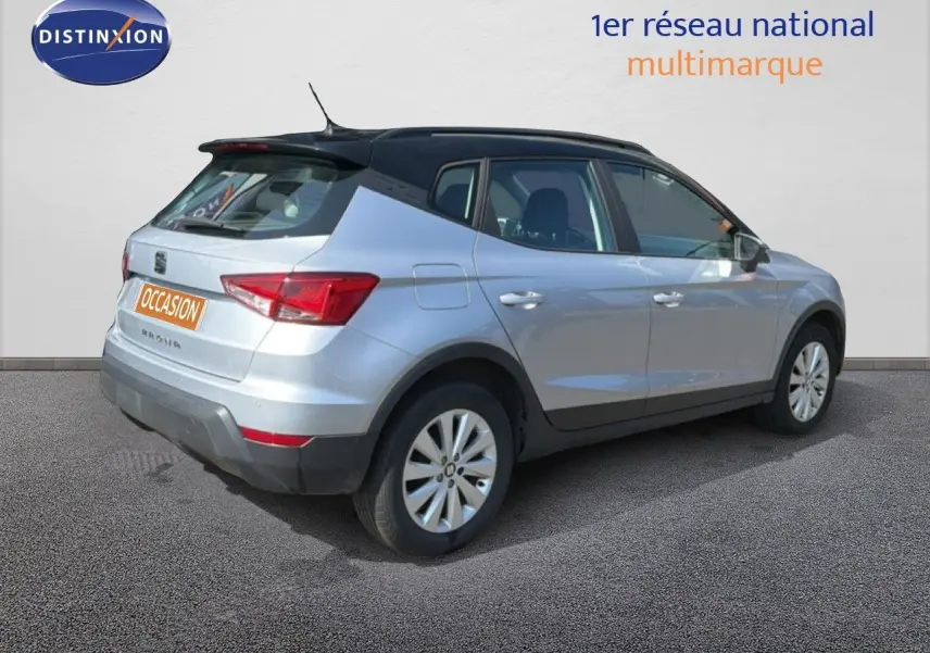 Vue 3/4 arrière droite d’un SEAT Arona gris urbain avec toit noir, modèle 2018, finition Style, en version essence 1.0 EcoTSI.