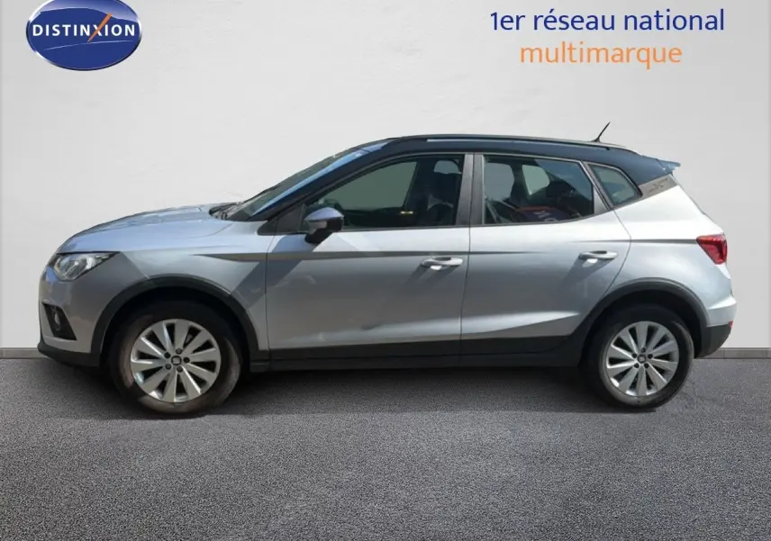 Vue latérale droite d'un SEAT Arona gris urbain avec toit noir, profil compact et lignes dynamiques visibles.