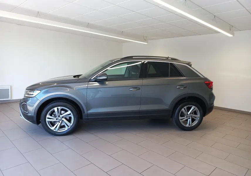 Volkswagen T-Roc 2025 gris Indium en profil droit, jantes alliage 17’’ Valencia et pneus avec écrous antivol.