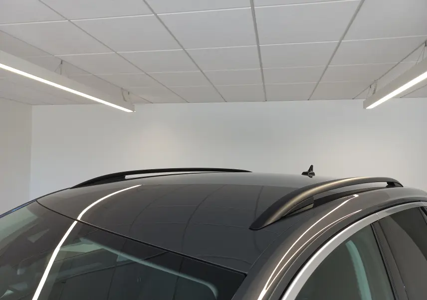 Toit panoramique noir et barres de toit noires du Volkswagen T-Roc Gris Indium, vue partielle en intérieur.