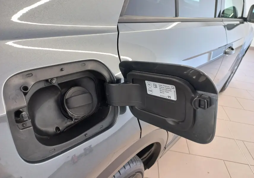 Vue rapprochée du côté gauche arrière du Volkswagen T-Roc gris Indium, avec trappe à carburant essence ouverte.