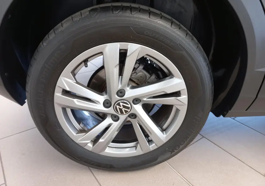 Gros plan sur la jante alliage 17 pouces Valencia du Volkswagen T-Roc gris Indium, avec écrous antivol visibles.