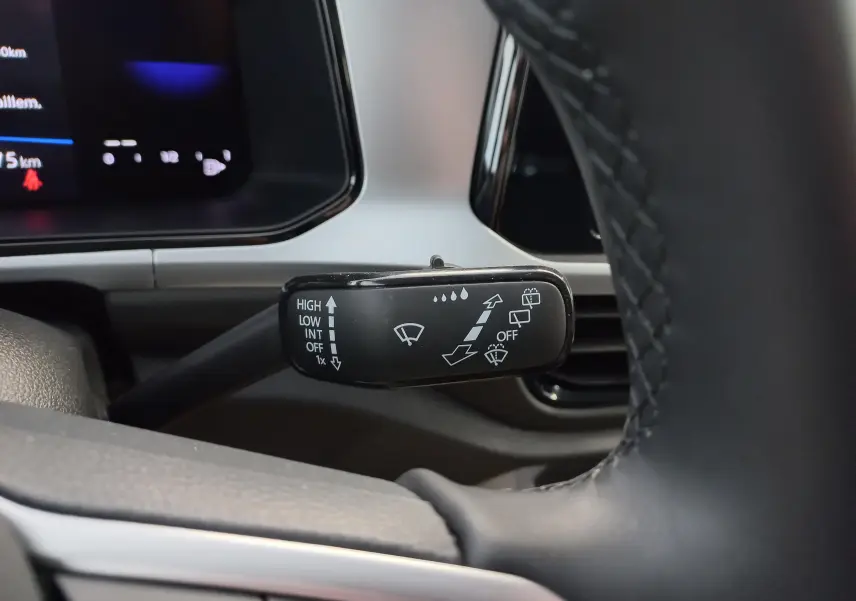 Gros plan sur la commande d'essuie-glace côté droit du volant dans l'habitacle du Volkswagen T-Roc Gris Indium.