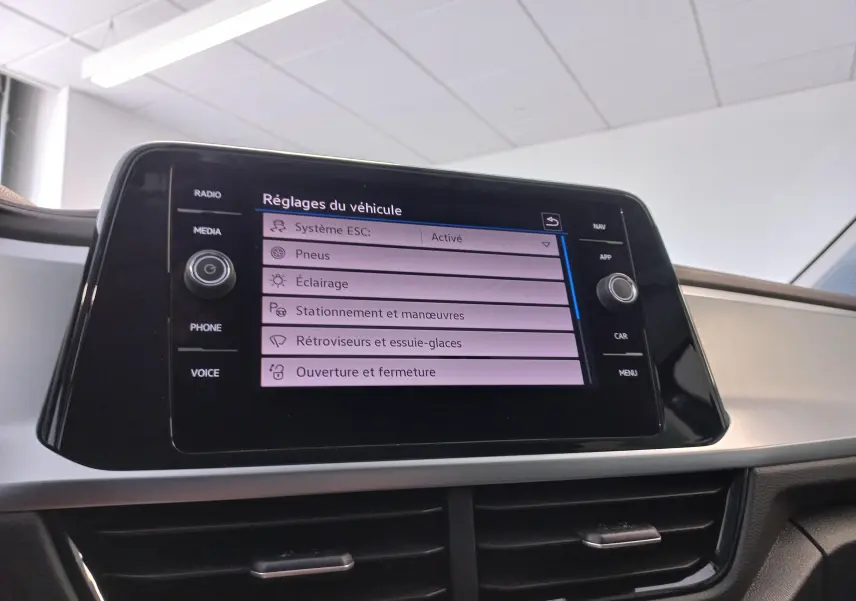 Écran tactile central du Volkswagen T-Roc 2025 affichant les réglages du véhicule dans un intérieur clair.