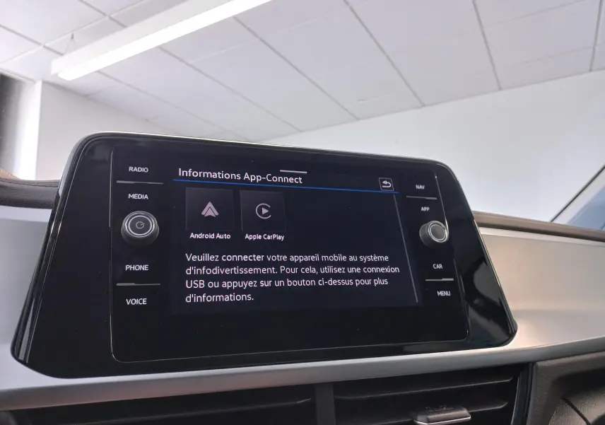 Écran tactile central du Volkswagen T-Roc 2025 affichant les options Android Auto et Apple CarPlay dans un intérieur clair.