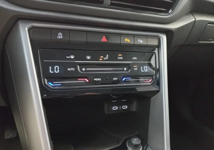 Vue rapprochée de la console centrale du Volkswagen T-Roc 2025, affichant la climatisation digitale et les ports USB.